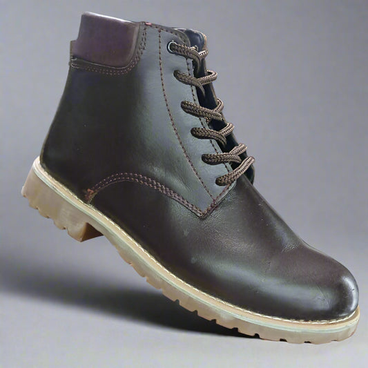 Brown leather boot held by a hand with a blurred background of shoes.