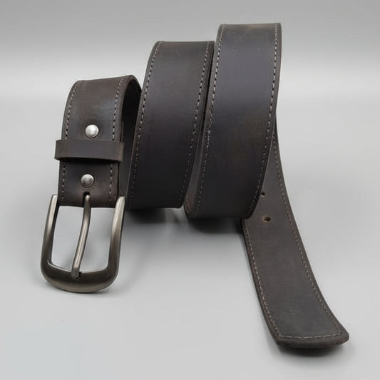 Brown leather belt with a silver buckle on a wooden surface