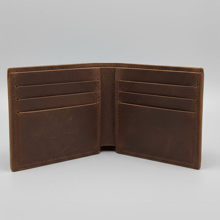 Brown leather wallet held by a hand with a blurred background