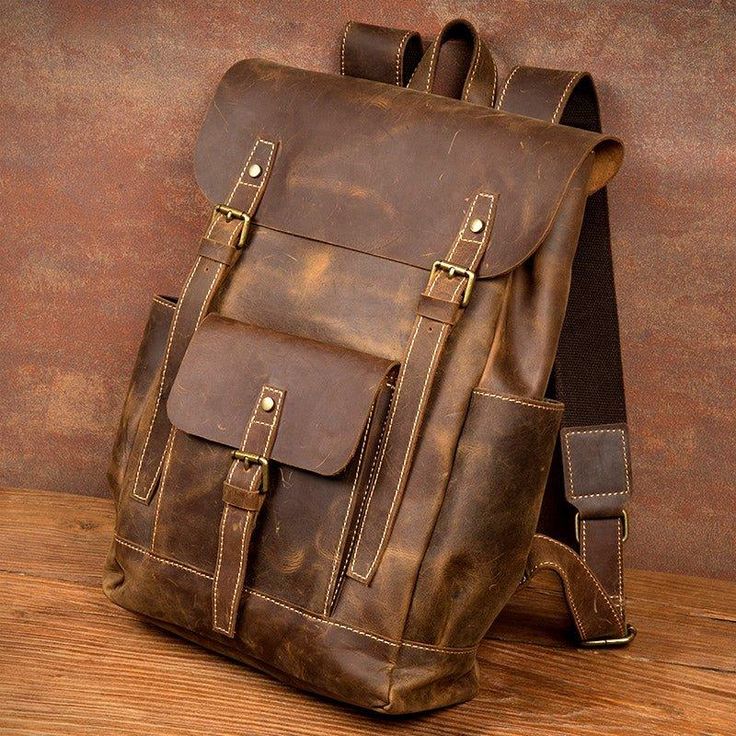 Brown leather backpack on a wooden surface with a brown background
