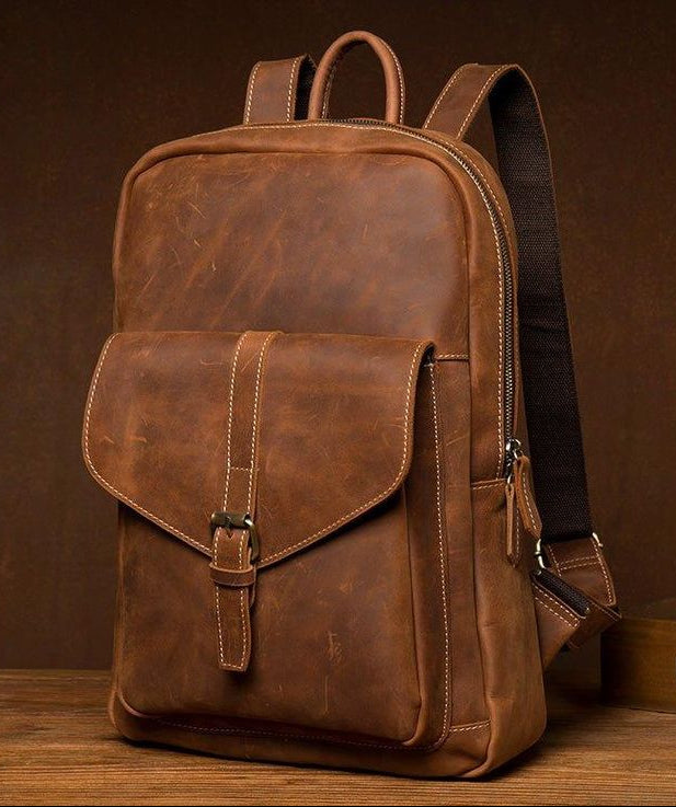 Brown leather backpack on a wooden surface with a brown background