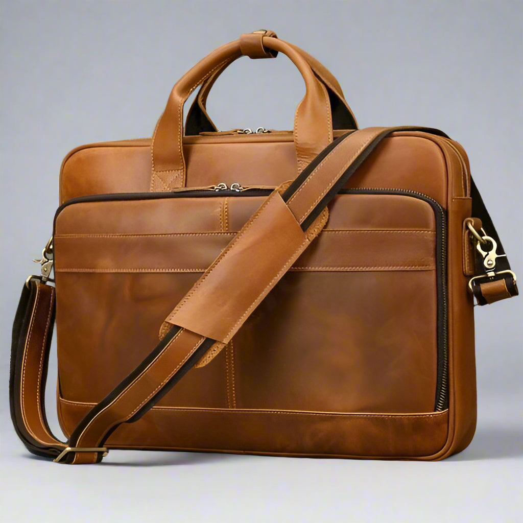 Brown leather briefcase with shoulder strap on a gray background