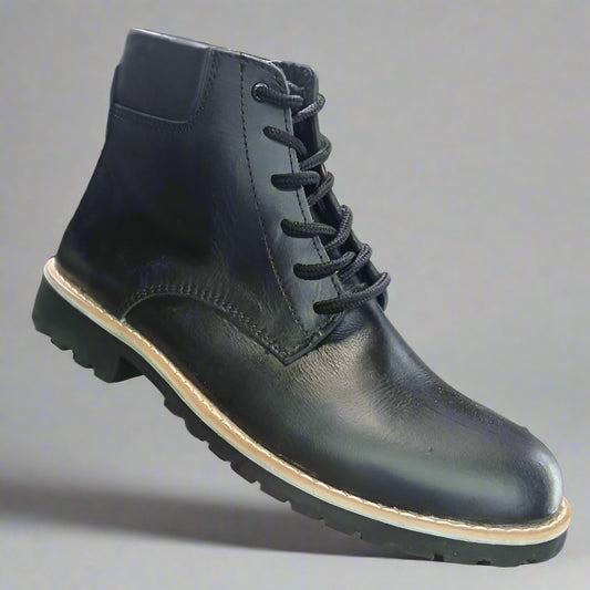 Black leather boot held in a hand with a shoe rack in the background