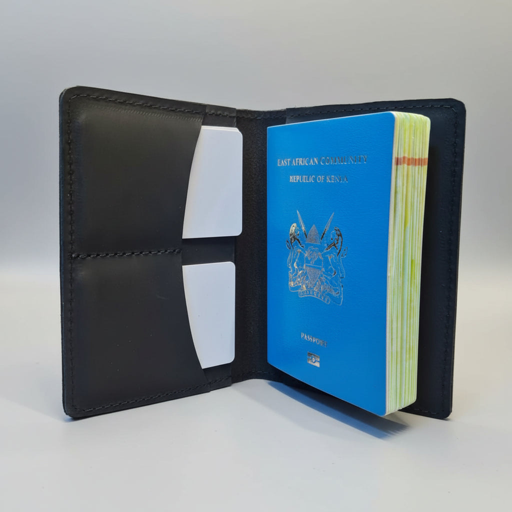 Black leather wallet with a blue passport on a wooden surface