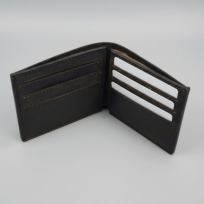 Open brown leather wallet on a wooden surface