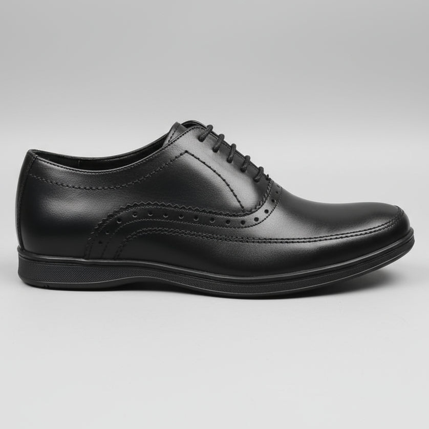 Black leather shoe on a wooden surface with orange boxes in the background