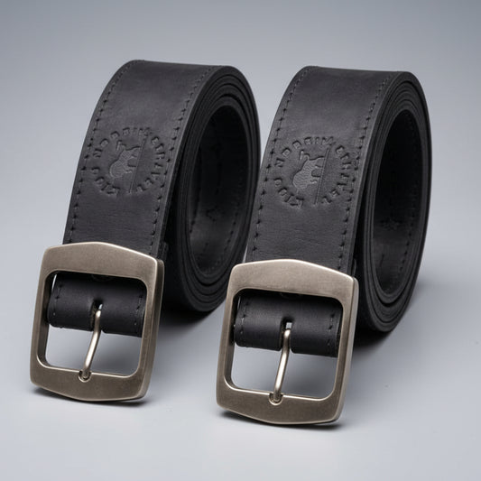 Two black leather belts with silver buckles on a dark background