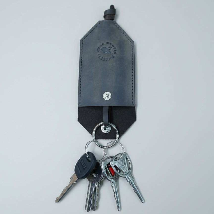 Coffee brown leather key holder with keys on a wooden surface