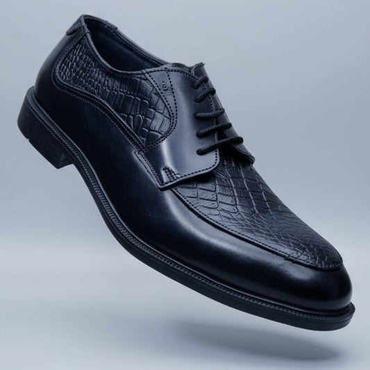 Black leather shoe held in a hand with blurred shoes in the background