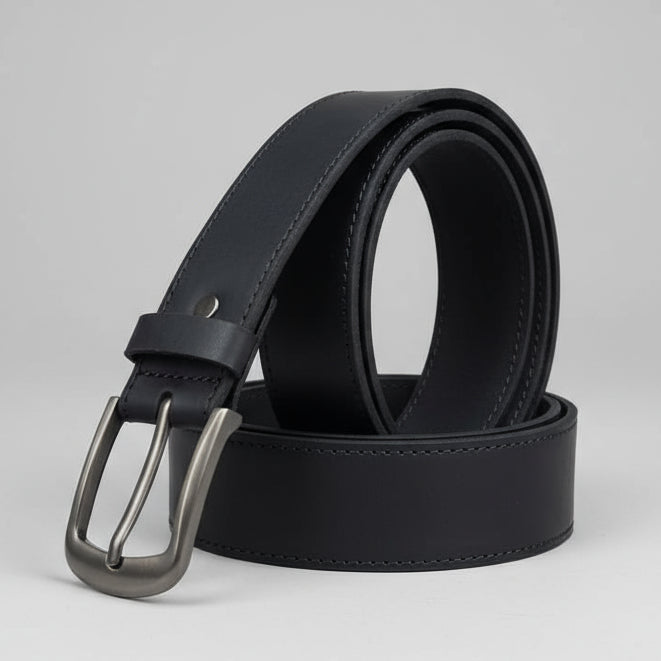 Black leather belt with silver buckle on a wooden surface