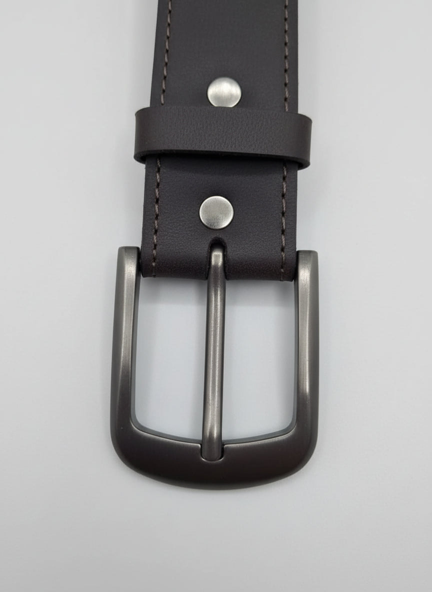 Brown leather belt with silver buckle on a wooden surface
