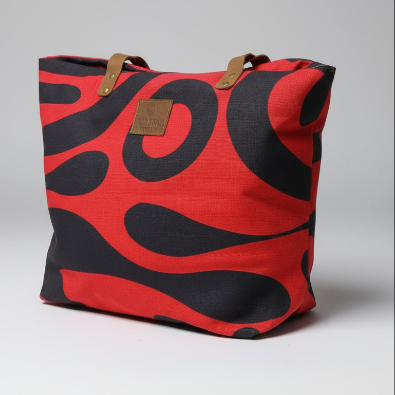 Red and black patterned bag with a brand logo on a wooden surface.