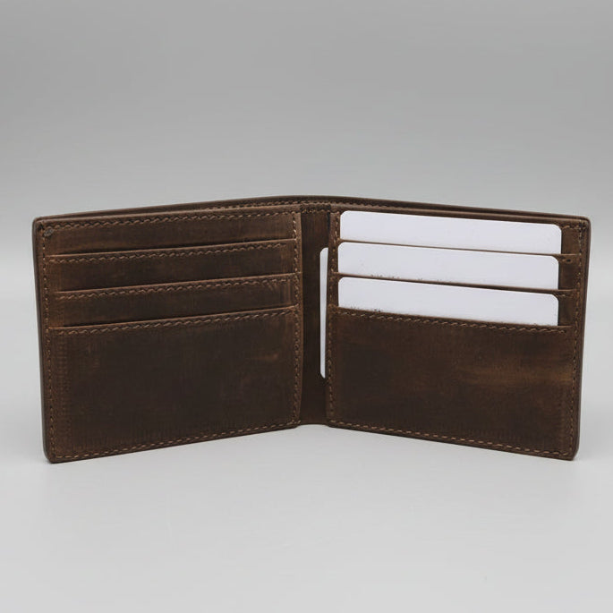 Brown leather wallet with card slots on a wooden surface