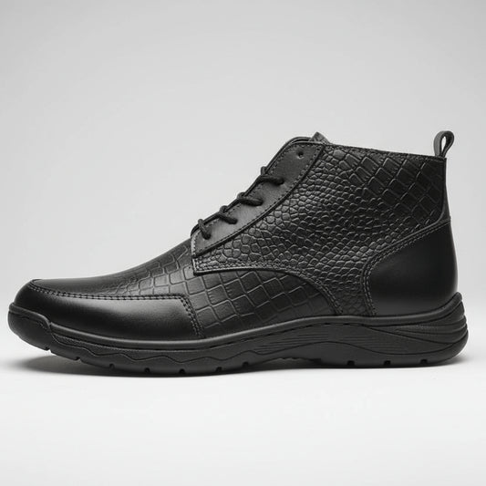 Black leather boot held in a hand with a blurred background