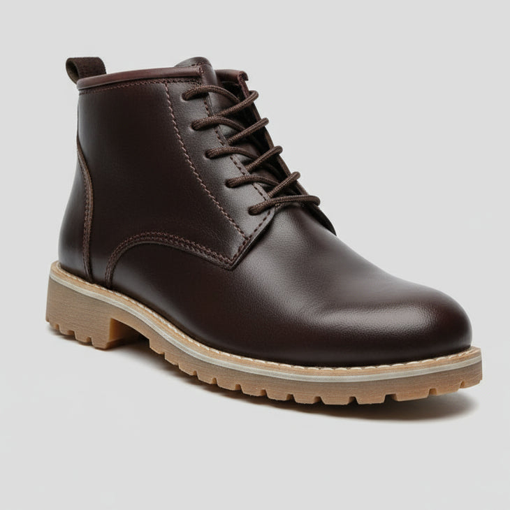 Brown leather boot held by a hand with a blurred background
