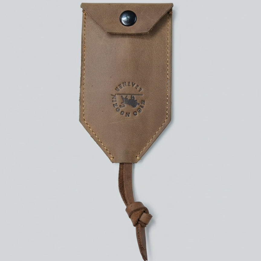Brown leather pouch with a knot on a wooden surface