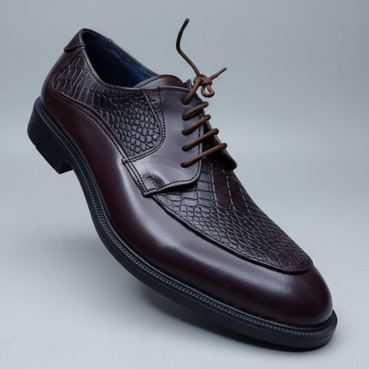 Brown leather shoe held in hand with blurred shelves in the background