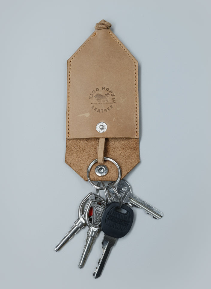 Leather keychain with keys on a wooden surface