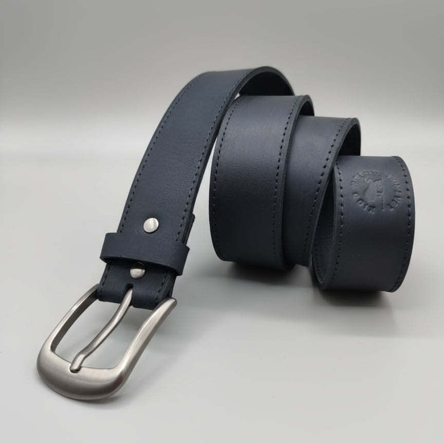 Black leather belt with silver buckle on a wooden surface