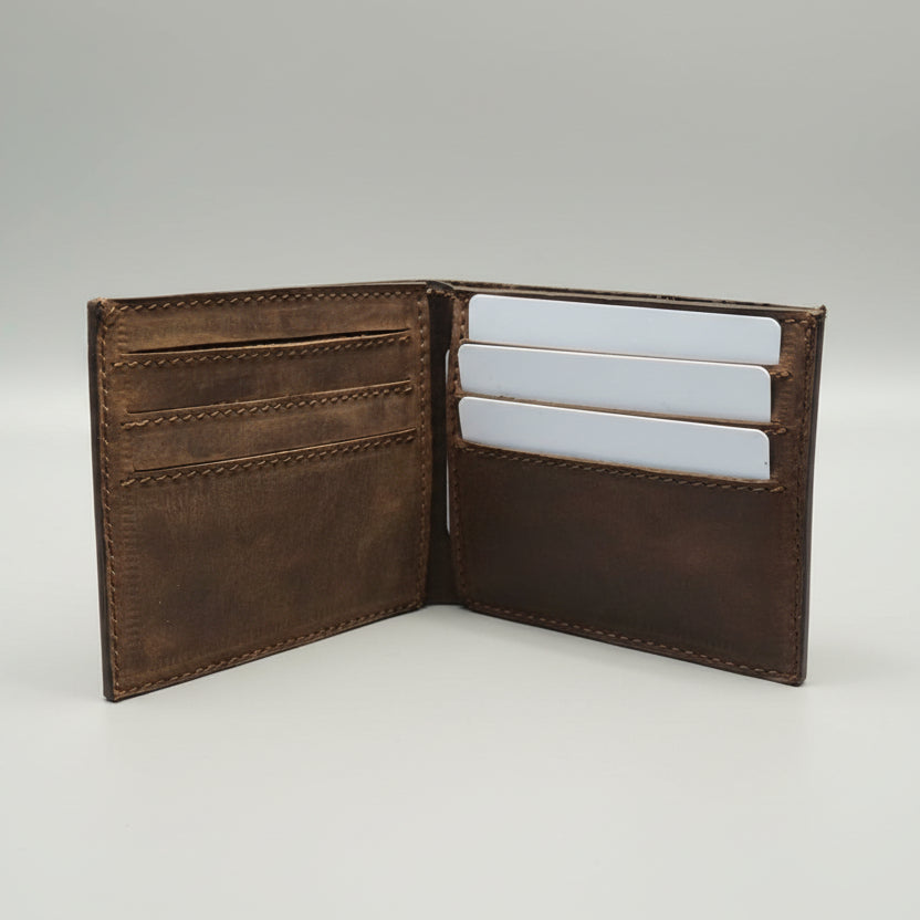 Brown leather wallet with card slots on a wooden surface