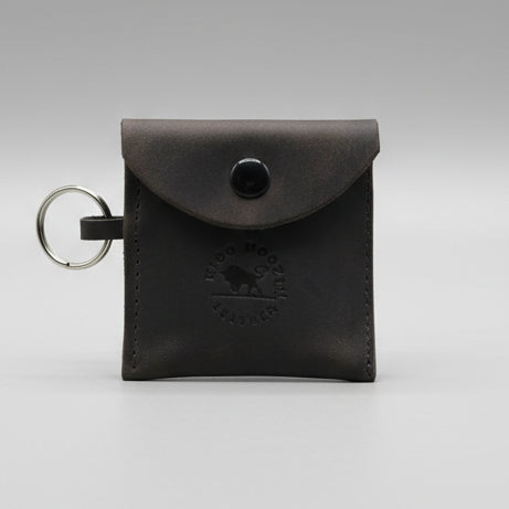 Coffee brown leather key fob with a brand logo on a wooden surface