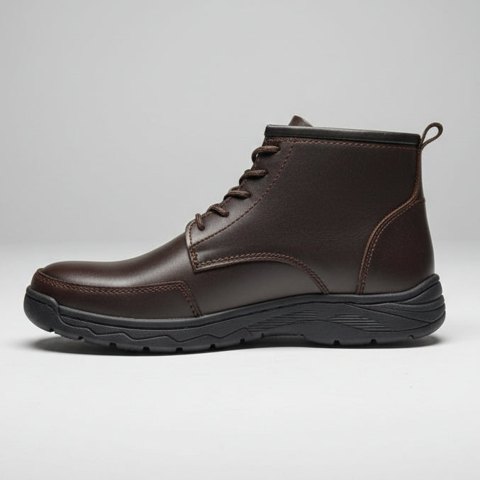 Brown leather boot held by a hand with a shoe store in the background