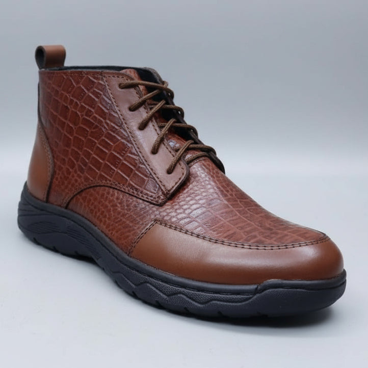 Brown leather shoe held in a hand with shelves of shoes in the background