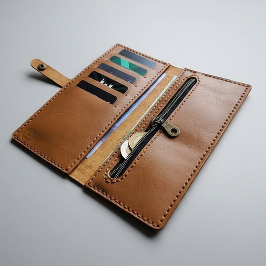 Brown leather wallet with zipper on a gray background