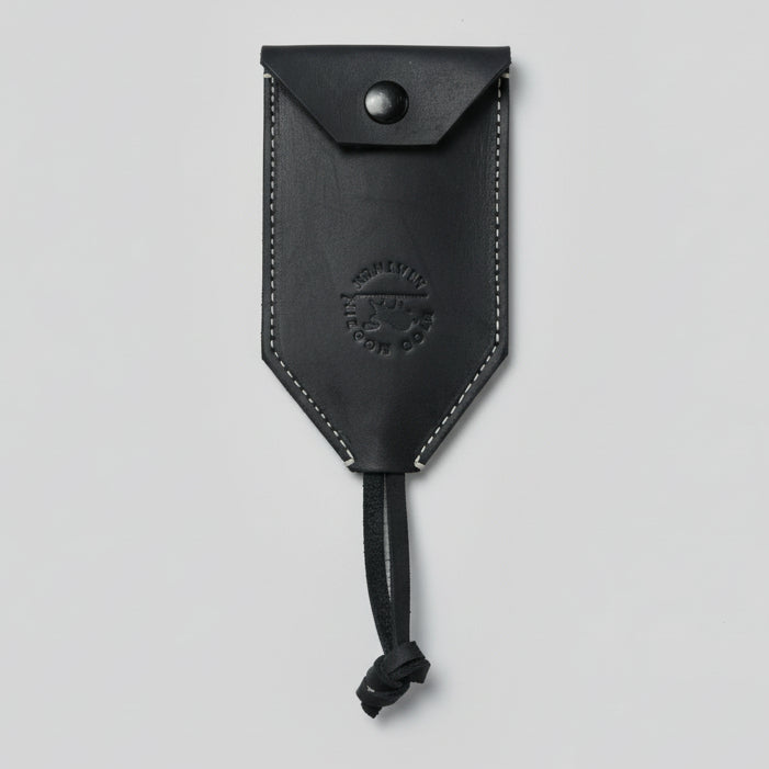 Black leather pouch with a strap on a wooden surface