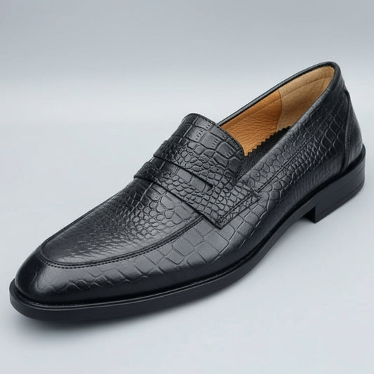 Black leather loafer held in a hand with shoe shelves in the background
