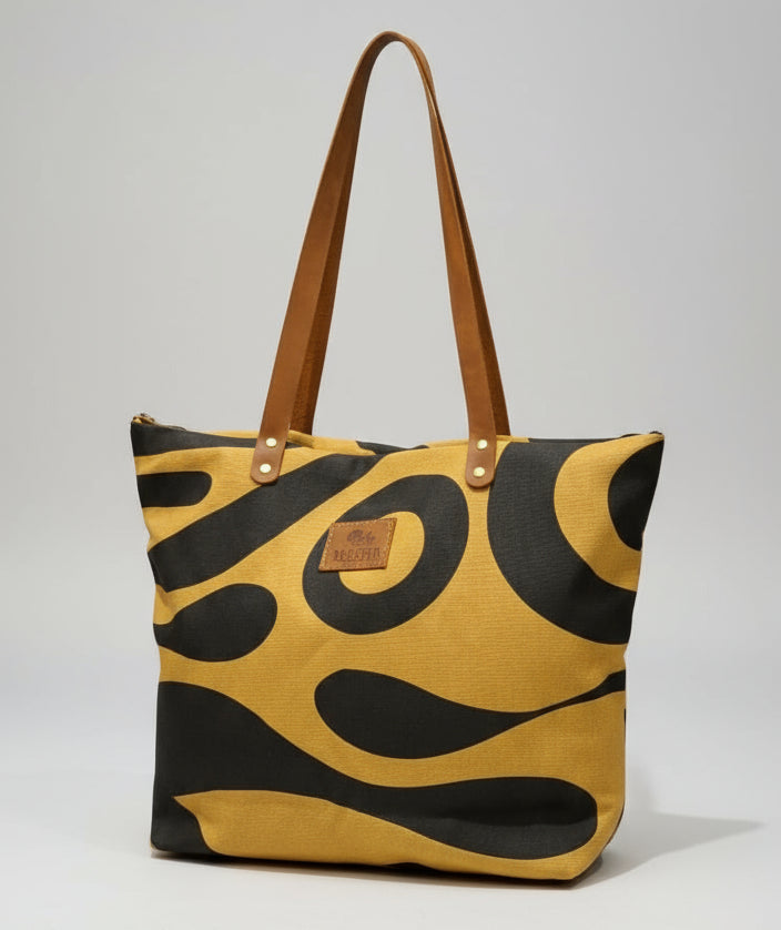 Person holding a yellow and black patterned bag in an indoor setting