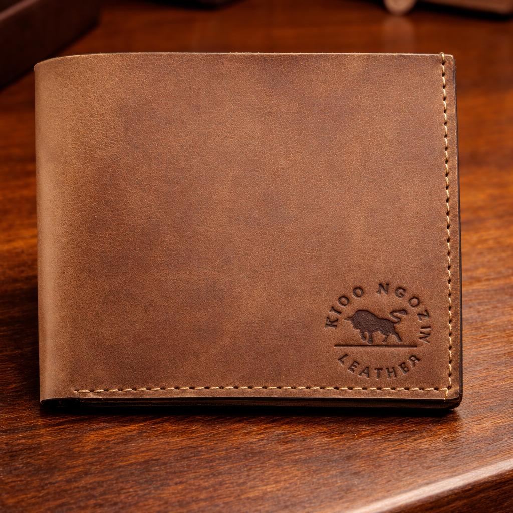 Brown leather wallet with a visible brand logo on a wooden surface