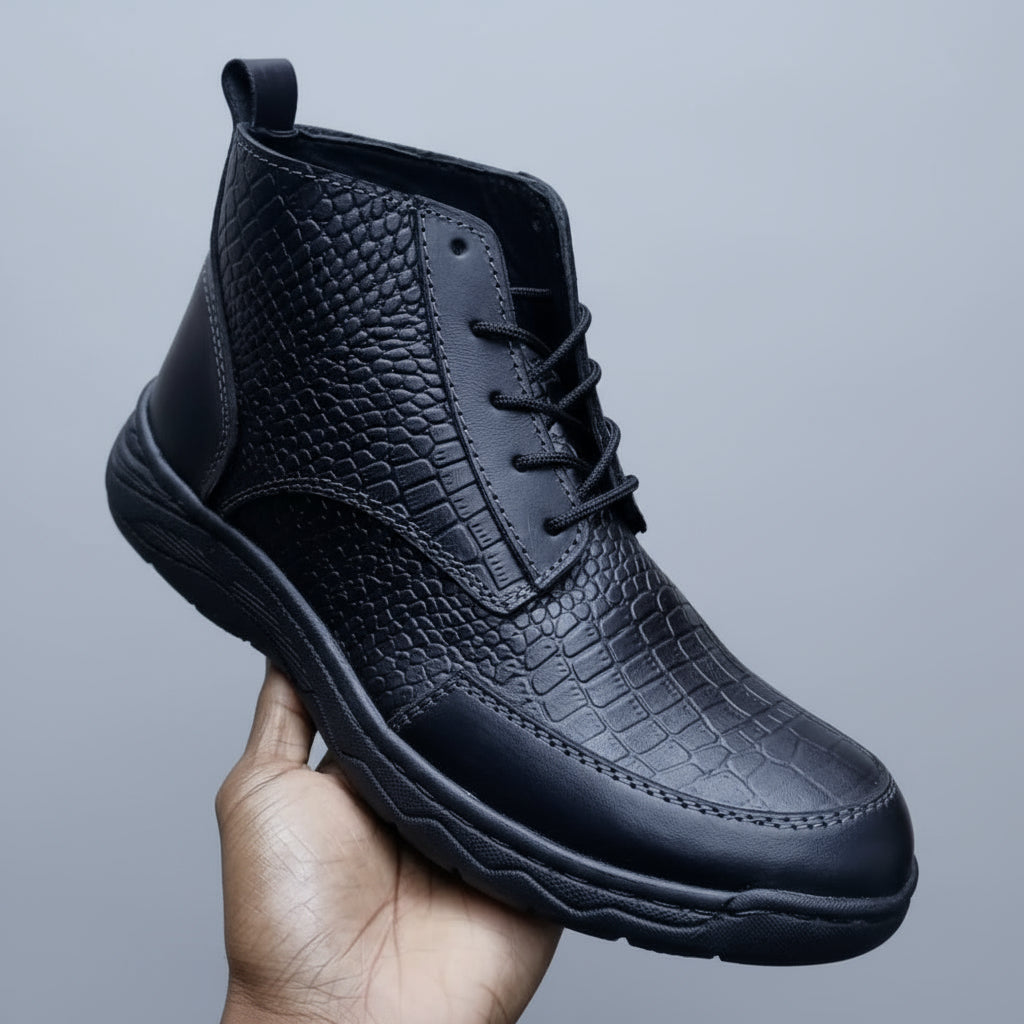 Black textured boot held in a hand with a shoe rack in the background