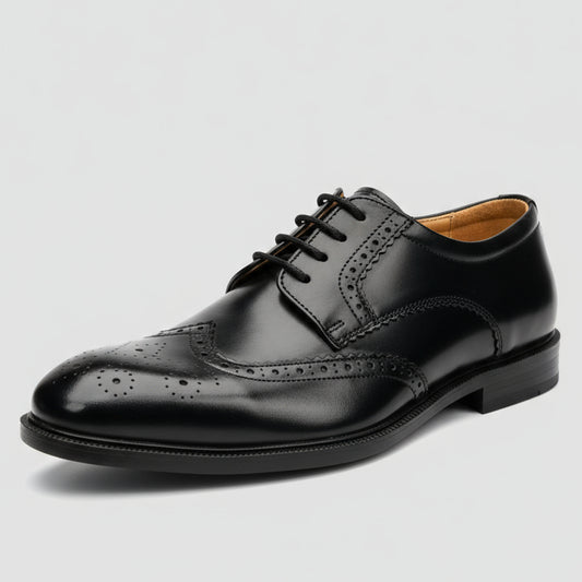 Black leather shoe held in a hand with shelves of shoes in the background