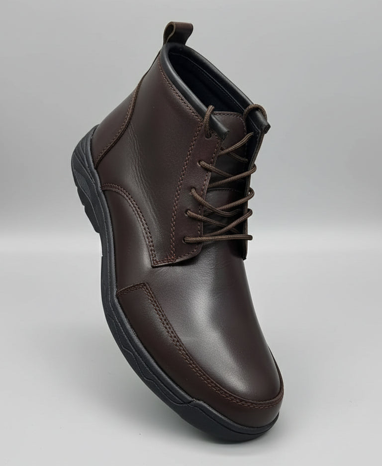 Brown leather shoe held by a hand with a blurred background