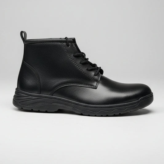 Black leather boot held by a hand with a pink wristband, against a blurred indoor background.